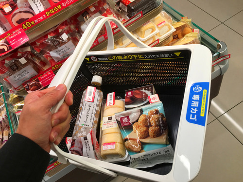 资料图:在日本大阪一家罗森便利店,顾客选购食品。新华社发