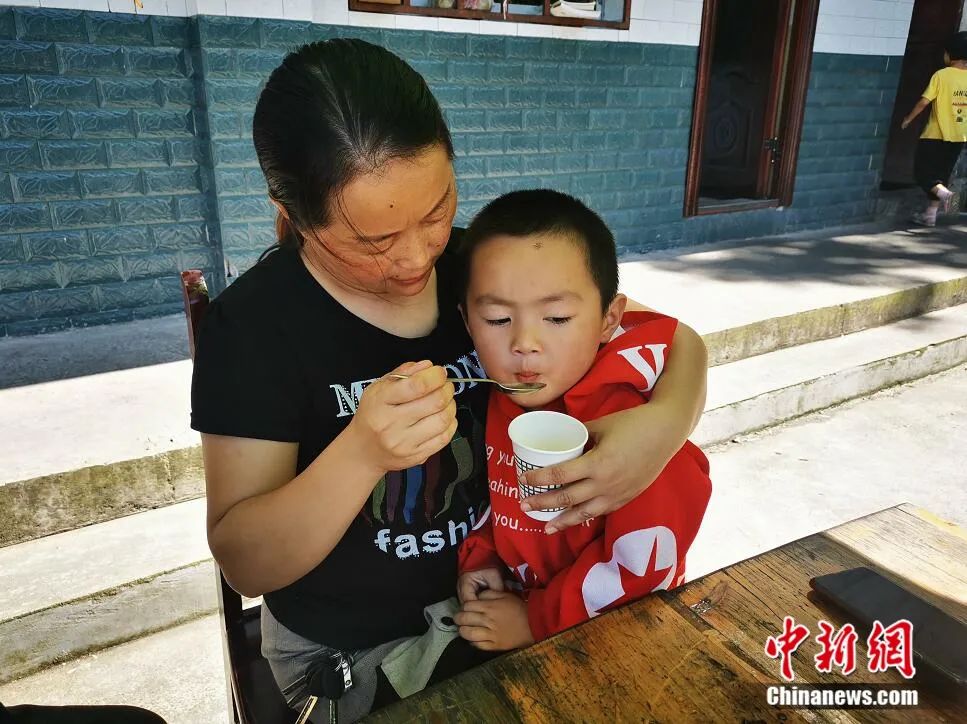 张蓉照顾年龄较小的学生喝水。苗志勇 摄