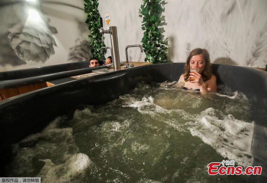 <p>Belgian yoga teacher Dorien Dierckx, 29 from Brussels enjoys a beer while relaxing in a jacuzzi full of hot water and a mixture of ingredients used to make beer, and where customers can serve their own beer from the tap at the Good Beer Spa in Brussels, Belgium May 12, 2021.(Photo/Agencies)</p>