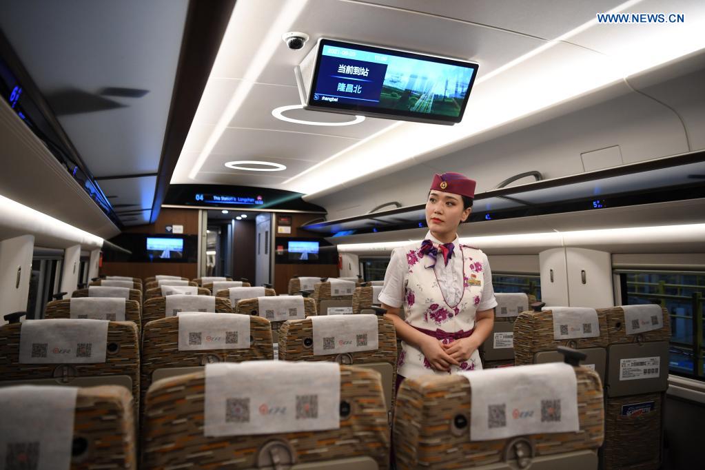 A crew member walks on a CR400AF Fuxing intelligent bullet train in southwest China's Chongqing, June 23, 2021. The CR400AF Fuxing intelligent bullet train will be put into service on the railway linking Chengdu, capital city of southwest China's Sichuang Province, and Chongqing on Friday. (Xinhua/Tang Yi)