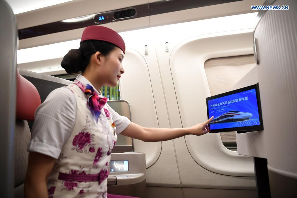 A crew member shows the function of on-board equipment on a CR400AF Fuxing intelligent bullet train in southwest China's Chongqing, June 23, 2021. The CR400AF Fuxing intelligent bullet train will be put into service on the railway linking Chengdu, capital city of southwest China's Sichuang Province, and Chongqing on Friday. (Xinhua/Tang Yi)