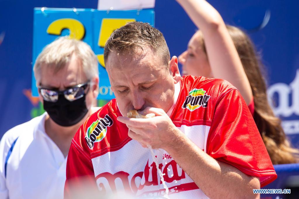 Joey Chestnut (front) competes in a hot dog eating contest in New York, the United States, on July 4, 2021. Defending champion Joey Chestnut broke his own world record Sunday by devouring 76 hot dogs in 10 minutes at the contest. Michelle Lesco won the women's title by eating 30.75 hot dogs in 10 minutes. (Xinhua/Michael Nagle)