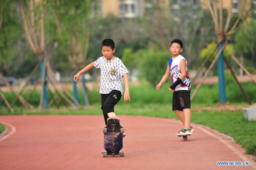 Children have fun along the Grand Canal in Cangzhou City of north China's Hebei Province, on July 6, 2021. Authorities in Cangzhou City has been actively promoting the Grand Canal culture by improving scenery along the watercourse so that visitors may have close experience with its beauty. (Xinhua/Luo Xuefeng)