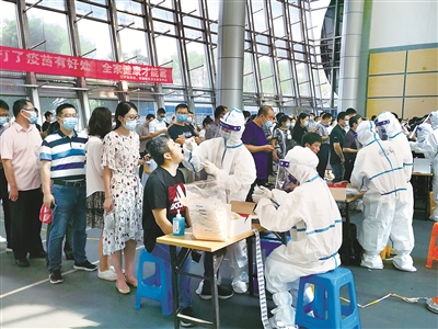 南京市江宁区在全区紧急设置551个临时核酸检测点,对全区范围内居民开展全员核酸检测。图为江宁区医护人员在临时检测点进行核酸采样。 摄影/胡重义(江宁区纪委监委干部)