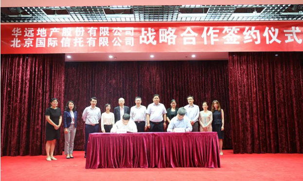 华远地产总经理李然(右)与北京信托总经理何晓峰(左)代表企业签约