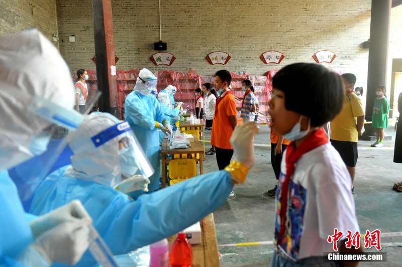 福州市医务人员正在为学生进行咽拭子采样。图源:中新网 吕明/摄