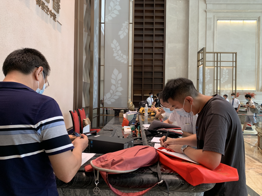 投资人正填写申请书。(陈月芹/摄)