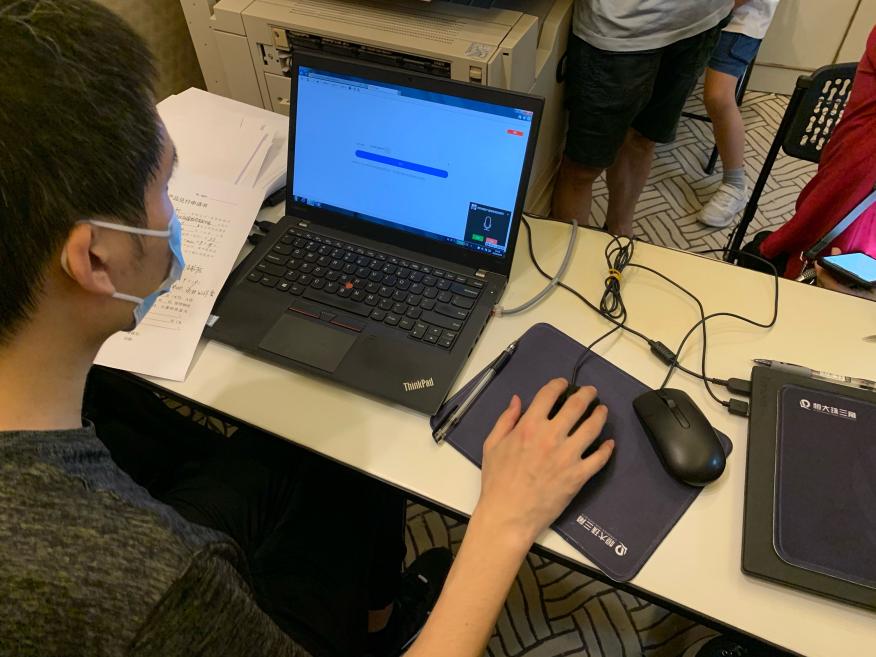 恒大财富工作人员正帮投资人录入信息,电脑端不断显示有客户要求与他语音通话,但他无暇接听。(陈月芹/摄)