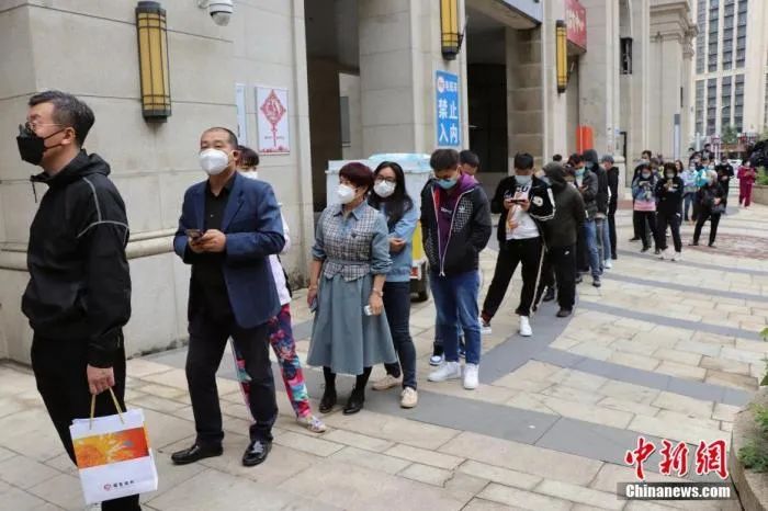 资料图:黑龙江哈尔滨南岗区市民井然有序地排队等待进行核酸检测.