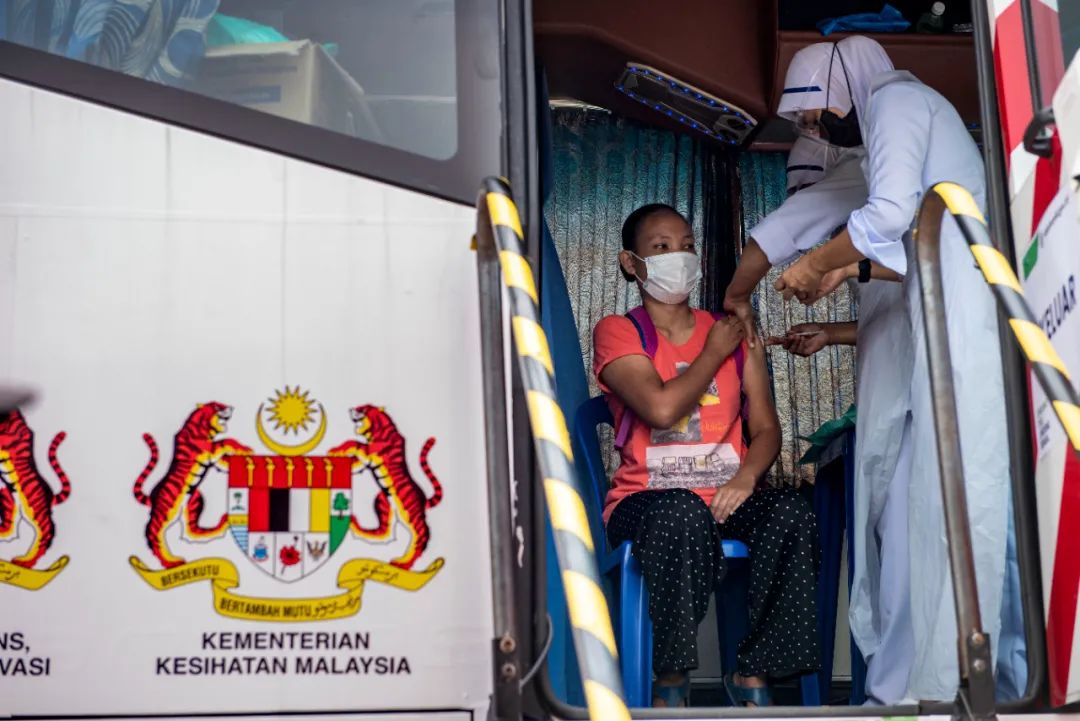 7月25日，马来西亚雪兰莪州凯里岛的居民在移动疫苗接种车上接种新冠疫苗。新华社发（张纹综摄）