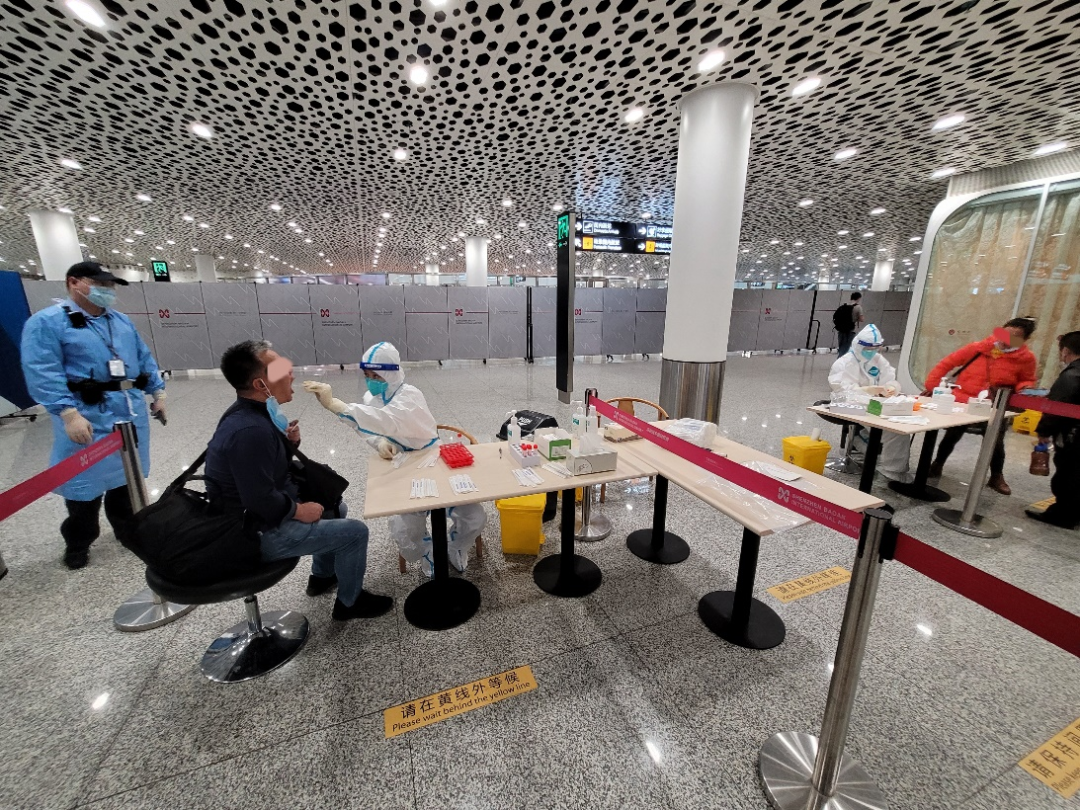 乘客在深圳机场内接受落地核酸检测.