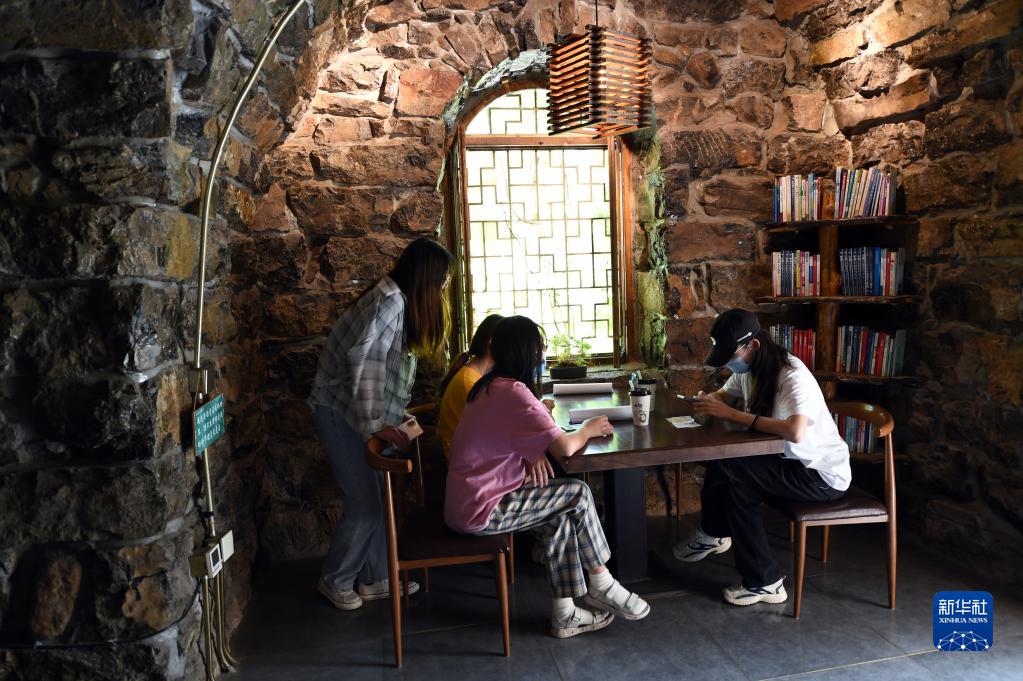 游客在吕家村老旧建筑改造而成的书吧休闲游玩。新华社记者 骆学峰 摄