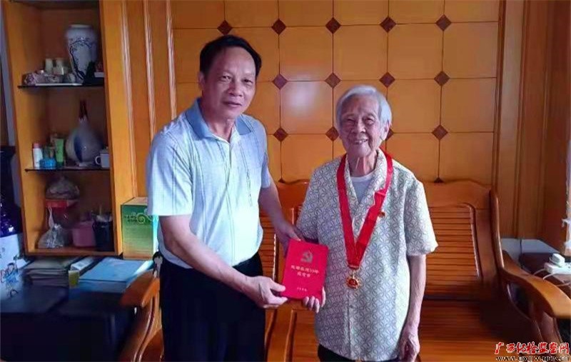 潘桂璇佩戴光荣在党50年徽章。