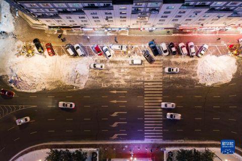这是11月24日拍摄的鹤岗市街道和堆积在道路旁的雪堆(无人机照片)。 新华社记者 谢剑飞 摄
