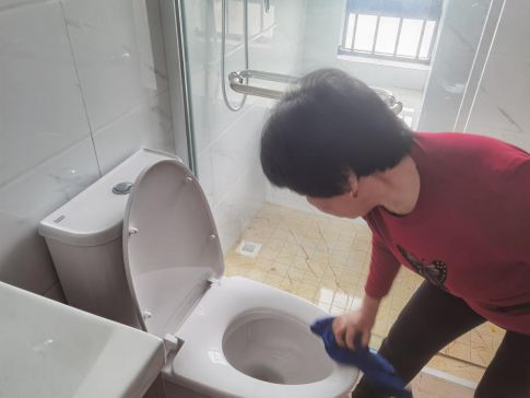 清洁阿姨正在擦拭马桶