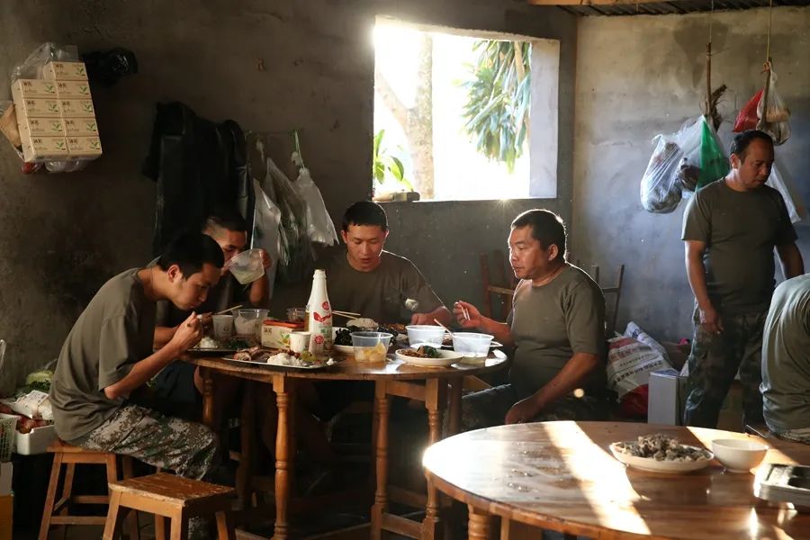 11月17日，瑞丽江边一处边境疫情防控值守点，执勤民兵吃晚饭。武晓慧 摄