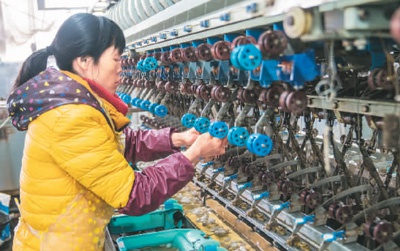 广西靖西市通过金融扶持的形式,引导农民栽桑养蚕,实现以企业发展带动产业扶贫发展,促进互利双赢。图为1月15日,农民工在靖西鑫晟茧丝绸公司车间工作。 刘润产摄(人民视觉)