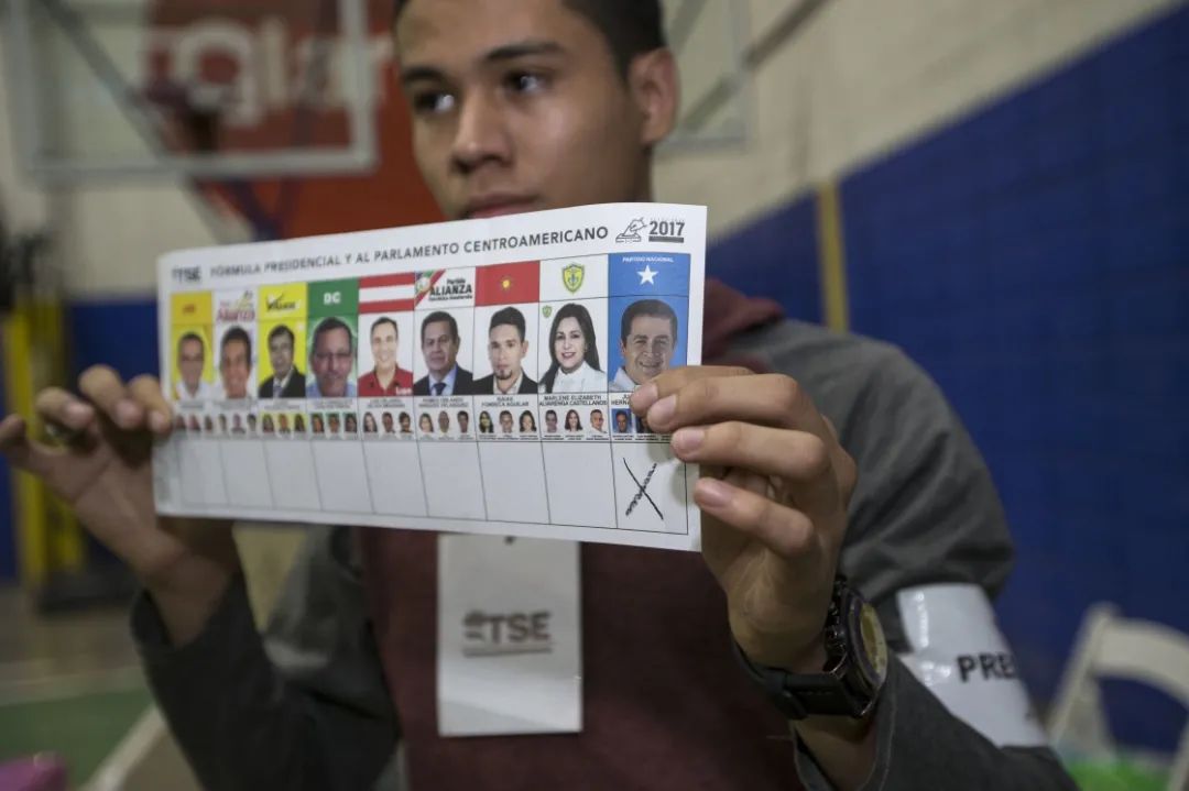 在洪都拉斯特古西加尔巴，一名工作人员展示一张选票  图：新华社/美联