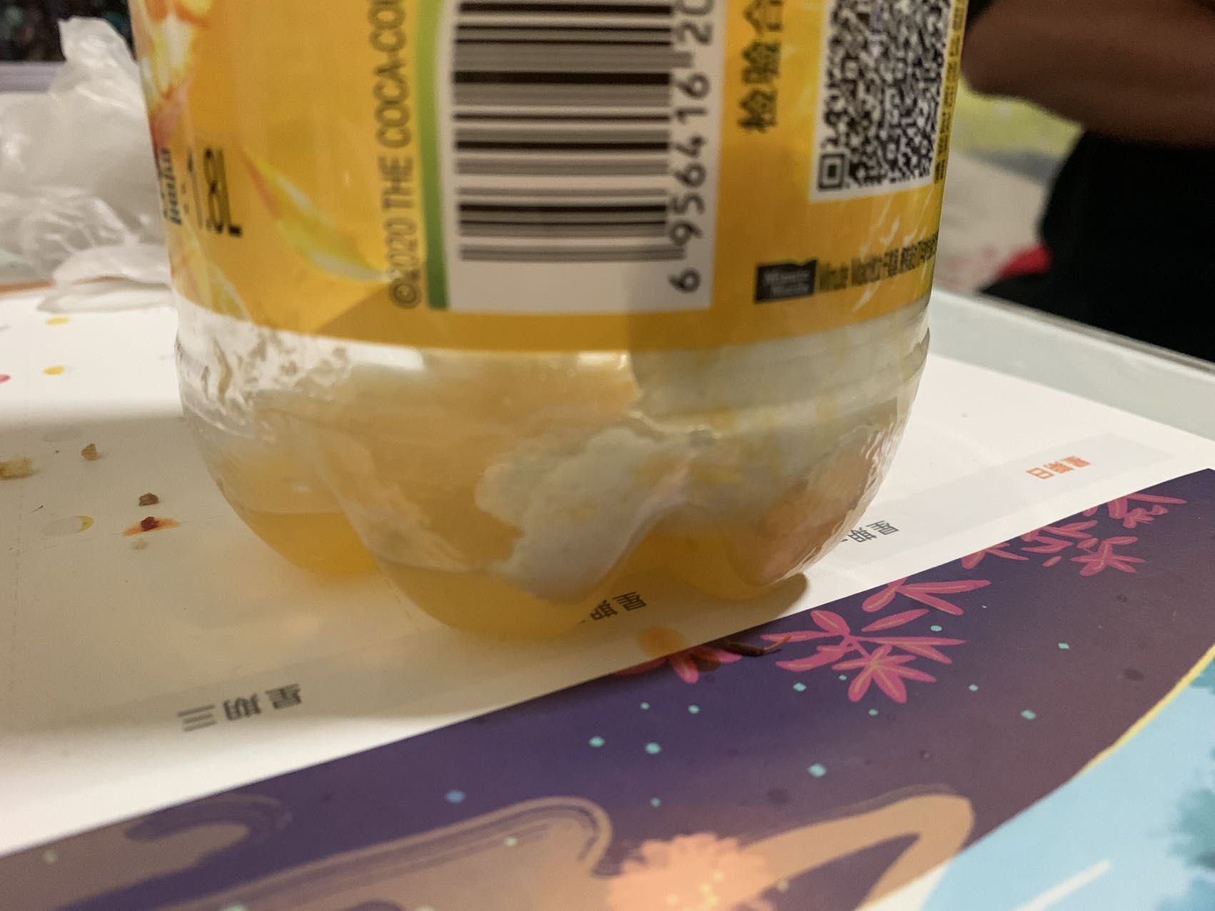 ▲程先生发现瓶底还粘有一片异物。 新京报记者 李睿阳 摄