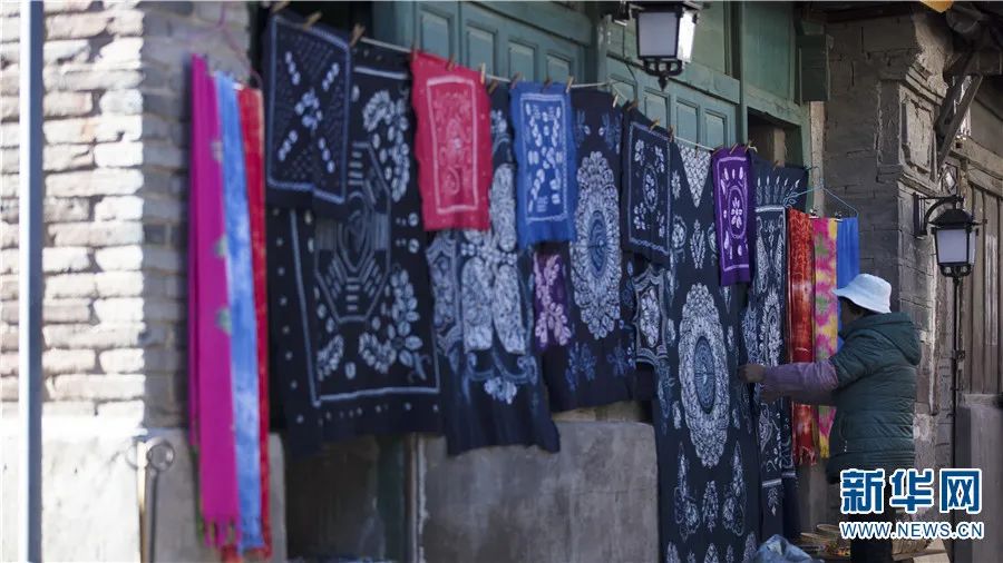 喜洲古镇，一位商户正在整理挂在墙上的扎染布（2020年12月14日摄）。丁凝 摄