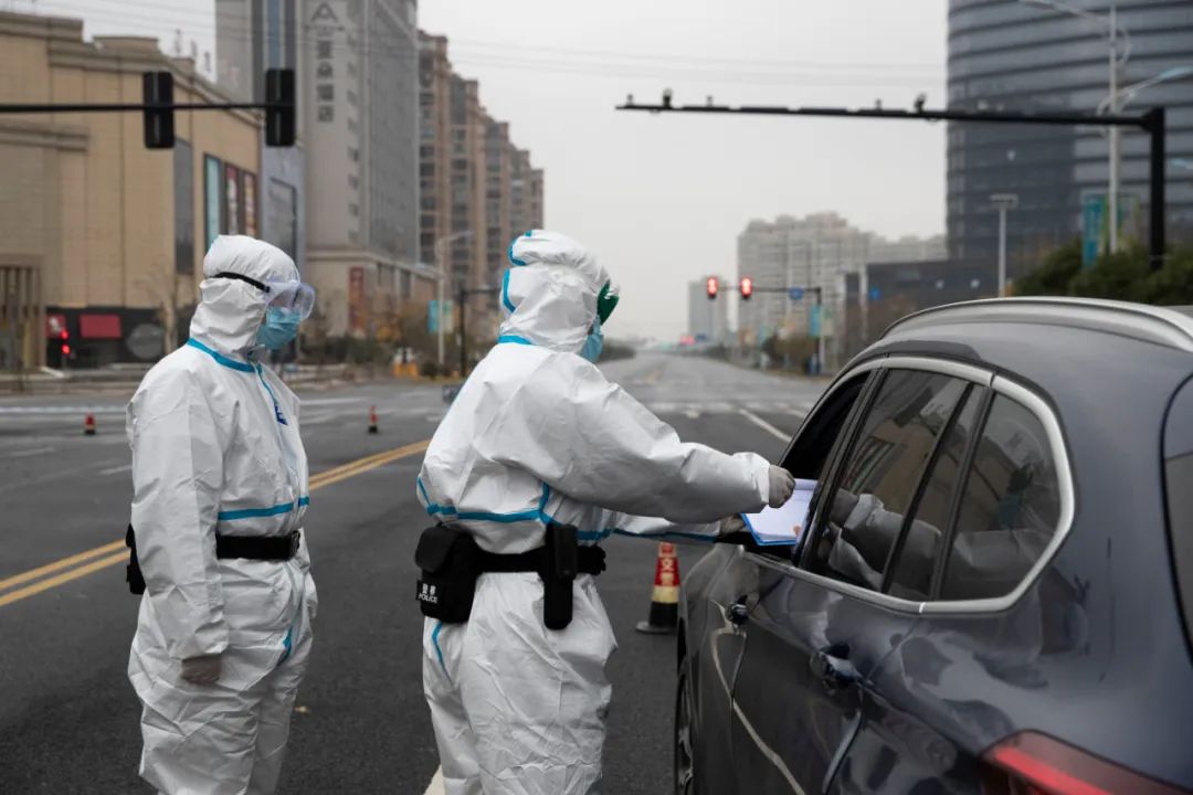 12月12日，疫情防控人员在浙江省绍兴市上虞区复兴路上对过往车辆和人员进行管控。图片来源：新华社