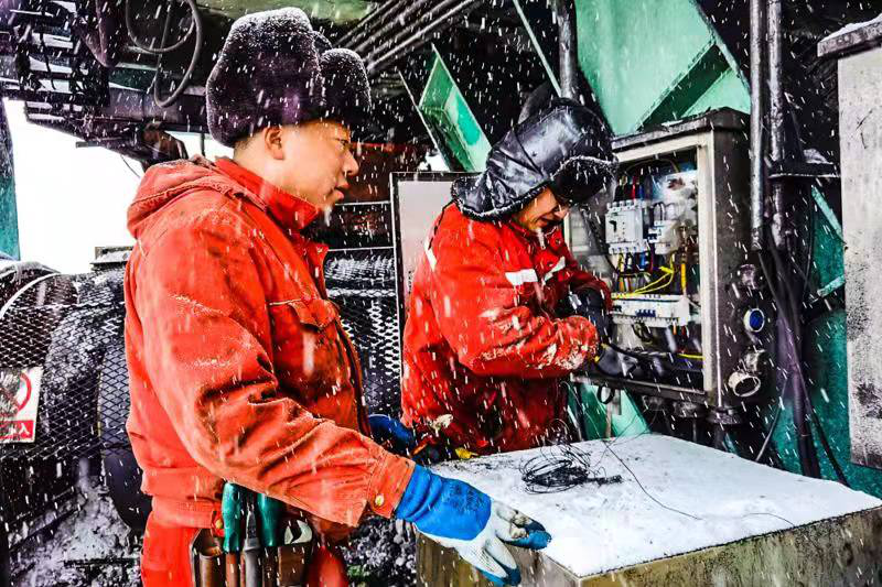 图为国家能源集团准能集团哈尔乌素露天煤矿的电工冒雪检修设备