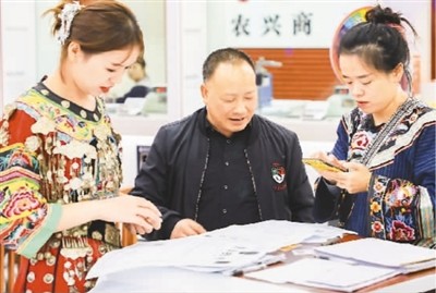 湖南吉首农村商业银行乾州支行2020年11月经改造升级后正式运营,为客户提供更加优质的服务。图为该支行工作人员为客户介绍业务。 张 慧摄(人民视觉)