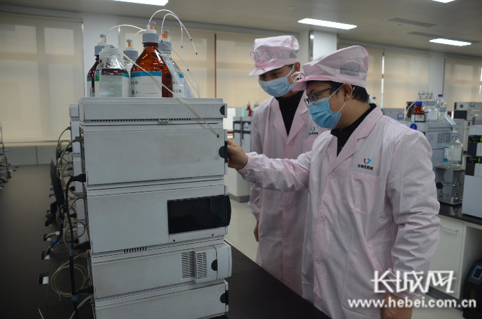石家庄四药研发中心液体制剂分析部部长袁广峰（右）和同事们坚守岗位，认真进行新产品开发实验。张航 摄