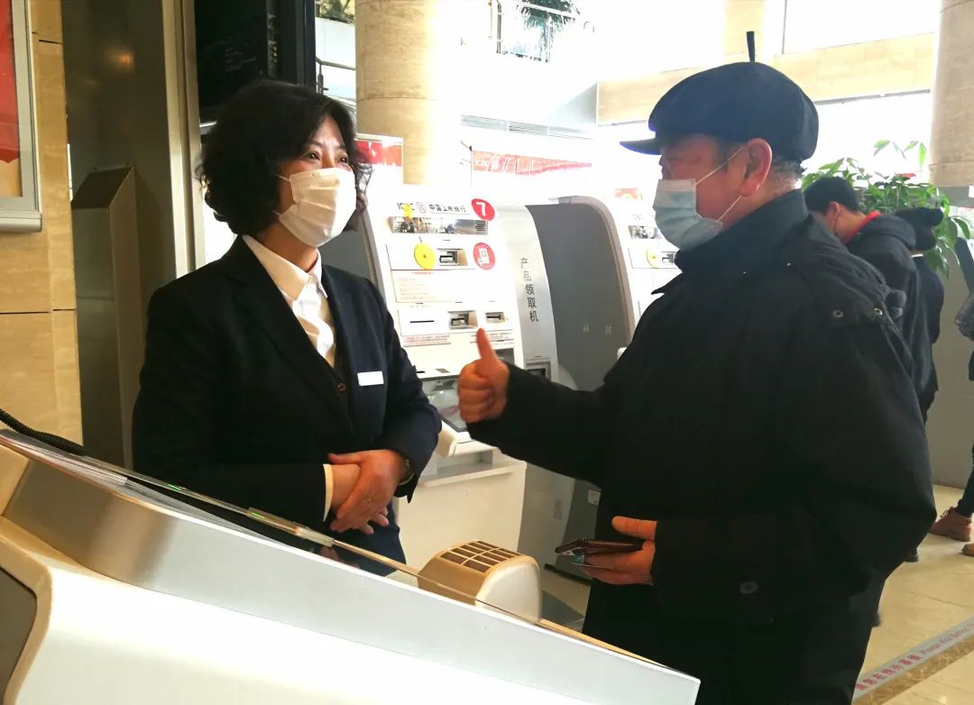 图为一位七十多岁老人向工商银行大连旅顺口支行客服经理耿慧丽竖起了大拇指,为她热情高效的工作点赞。