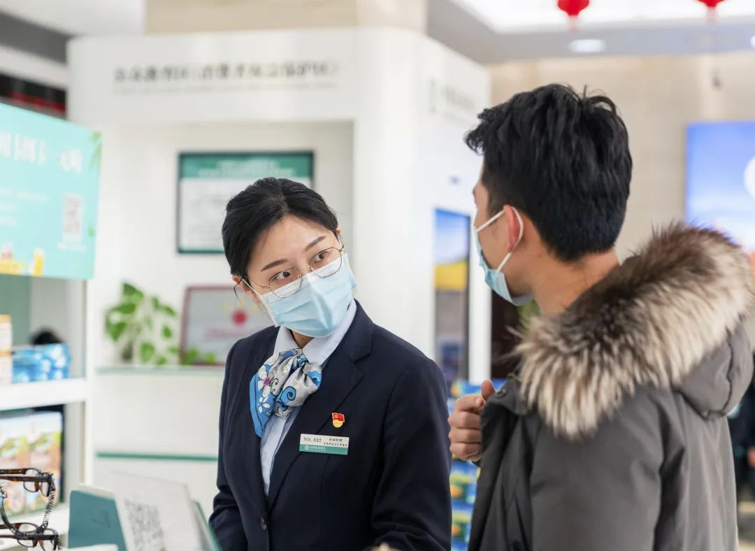 图为农业银行青岛分行工作人员仔细聆听顾客的需求。