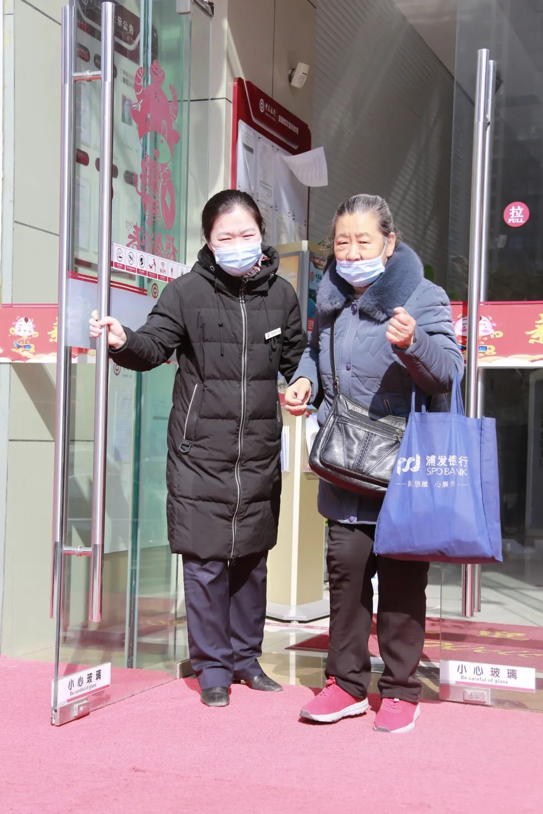 图为中国银行滁州分行营业部客户经理袁媛将客户送到营业部大门外。