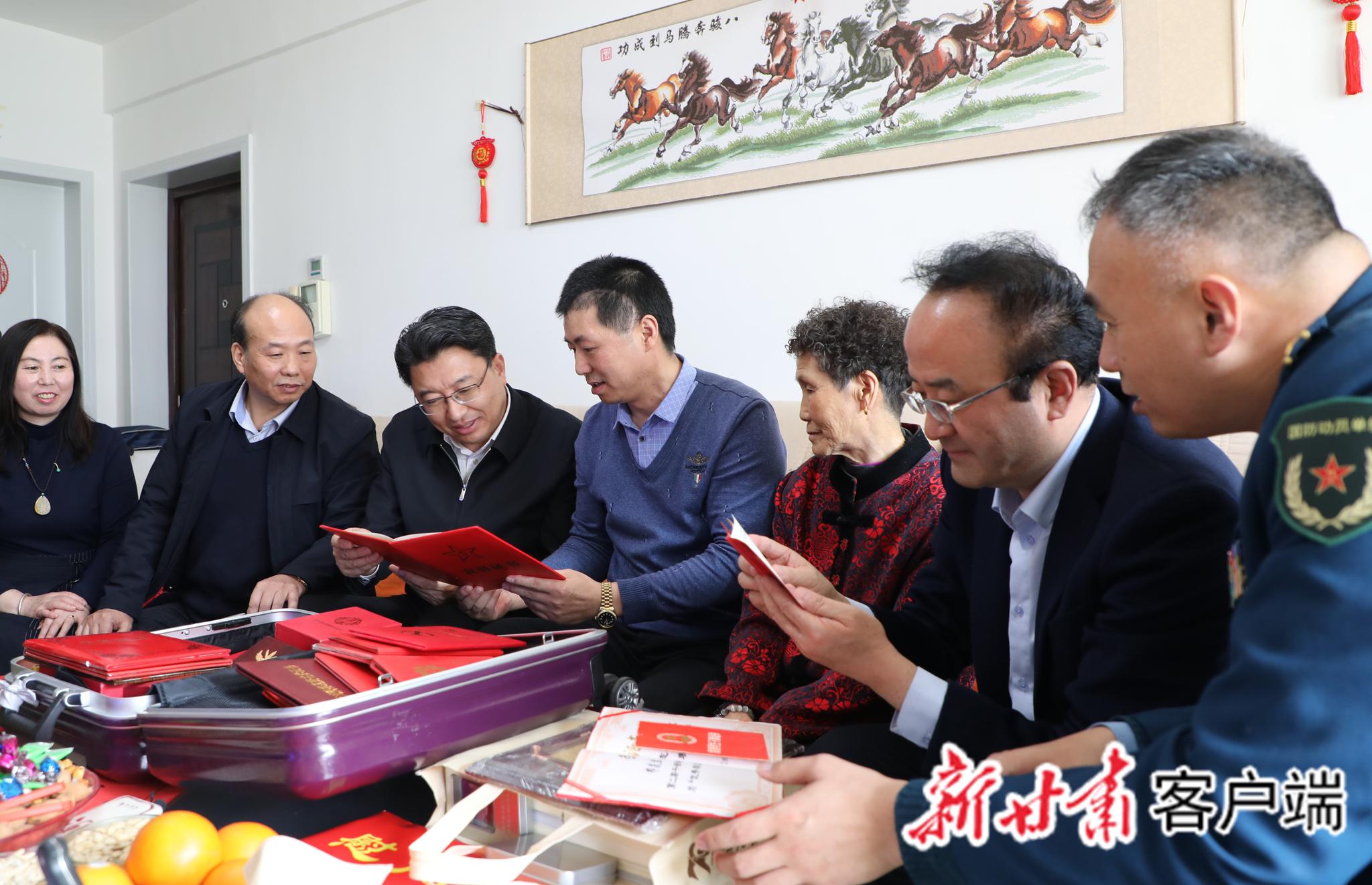 祁发宝(中)向来自家乡的慰问团介绍立功获奖情况。