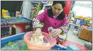 ◥年三十晚上,路彩恩忙里偷闲,在超市里和面,为年夜饭包饺子做准备。