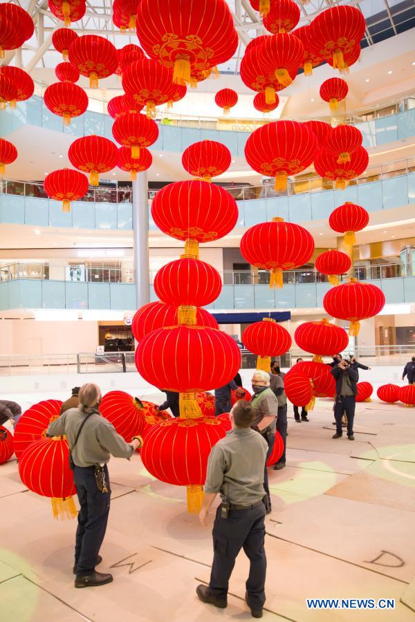 Staff members install red lanterns in Galleria Dallas shopping mall in