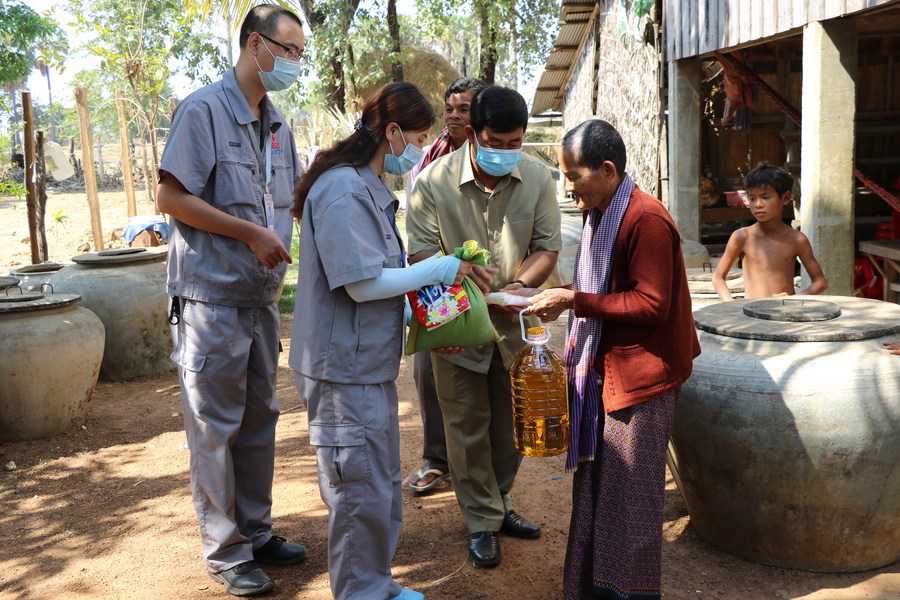 　　Chinese engineers bring daily necessities to rural families nearby a new well constructed under the Phase II of China-aided rural water supply and rural road projects in Cambodia in Kampong Speu Province of Cambodia, Jan. 15, 2021. (Xinhua/Zhang Zhao)