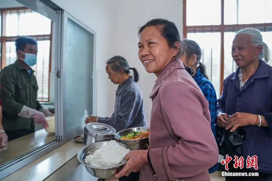 资料图:2月23日,广西隆安县东信村“爸妈食堂”内,老人们排队取餐。中新社记者 陈冠言 摄