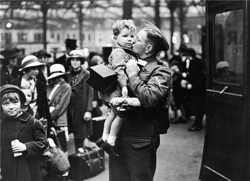 “二战”期间，大批男性在战争中失去生命或者入狱多年，很多家庭出现了没有父亲的现象，图为一名英国士兵在与儿子亲吻道别（视觉中国供图）