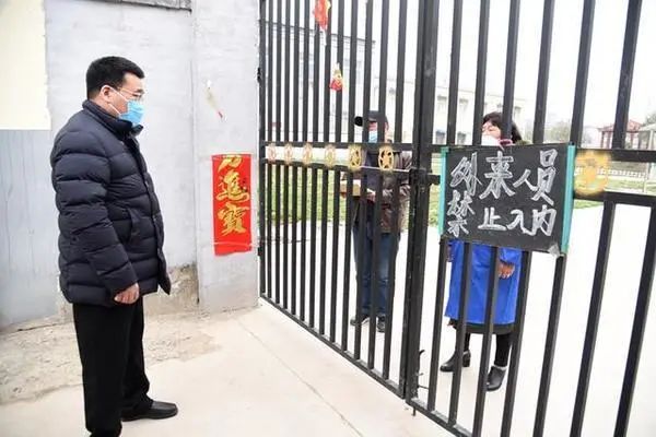 彭宾昌(左)与某敬老院负责人隔门对话(图源:大河报)