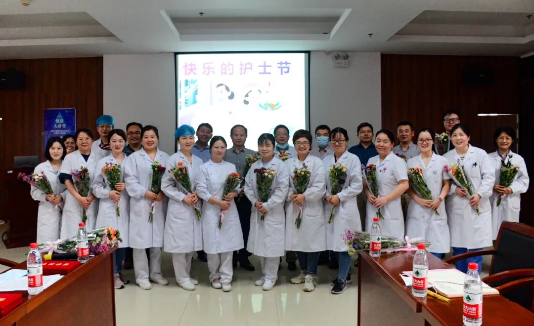 ▲王建鸿与学校职能部门负责人为护士们献上鲜花并合影留念