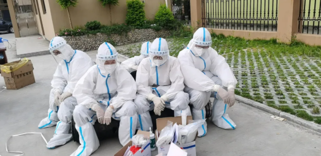 ▲通宵开展核酸检测后,医务人员就地小憩