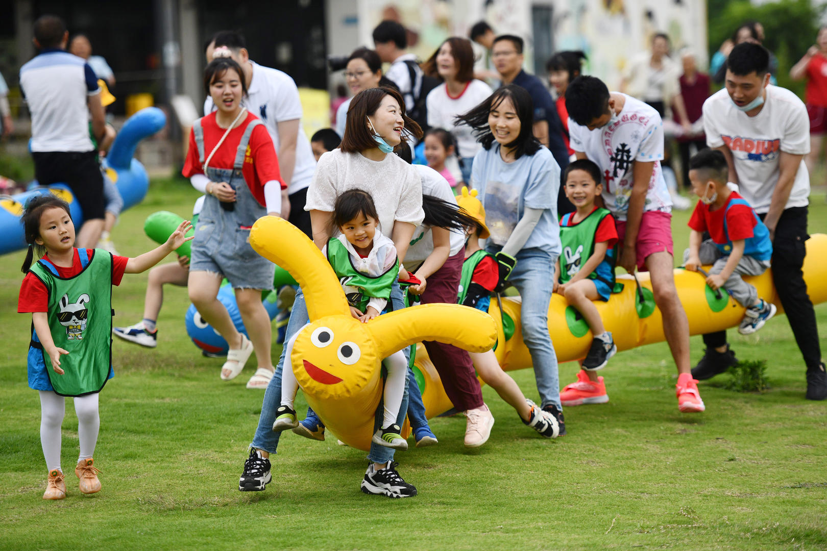 ↑资料图。2021年6月1日，成都孩童在家长的带领下来到一户外游乐场做亲子游戏。图据中新社