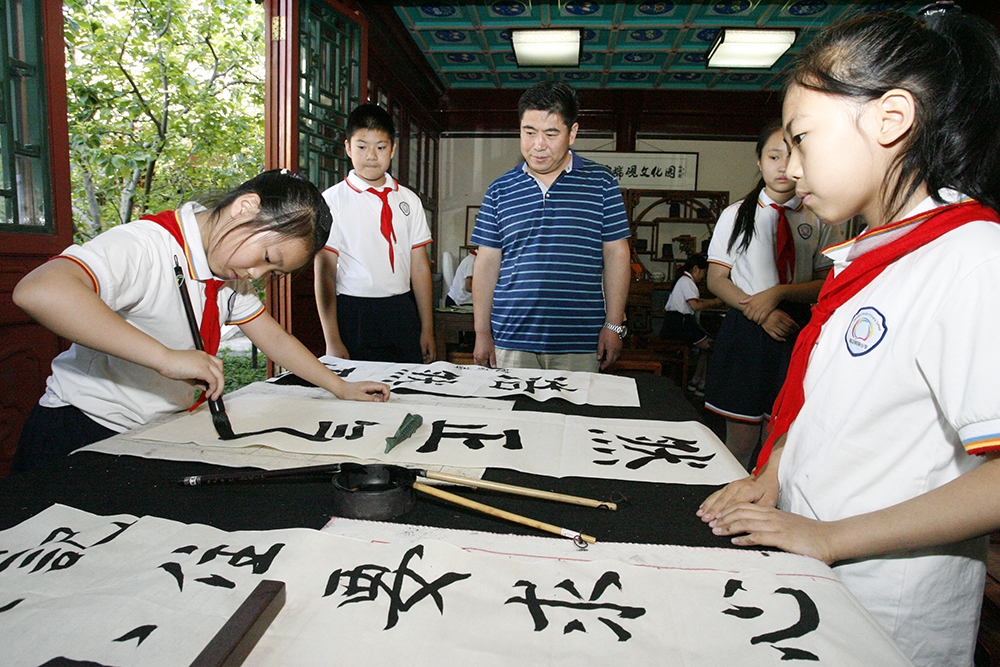 嘉宾在观看北京海淀区民族小学书法社团活动（2019年5月29日摄）。新华社记者 刘莲芬 摄