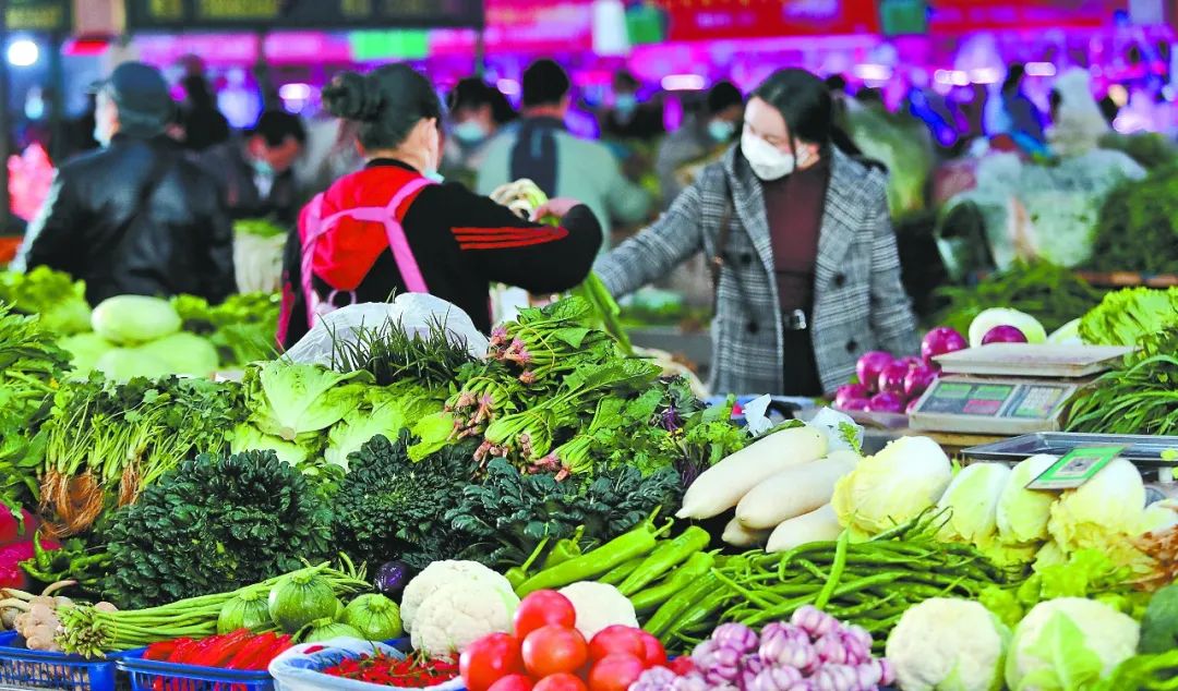 元旦假日，昆明市西山区和平综合农贸市场，赶早市的市民在选购蔬菜。杨峥 黄兴能 摄