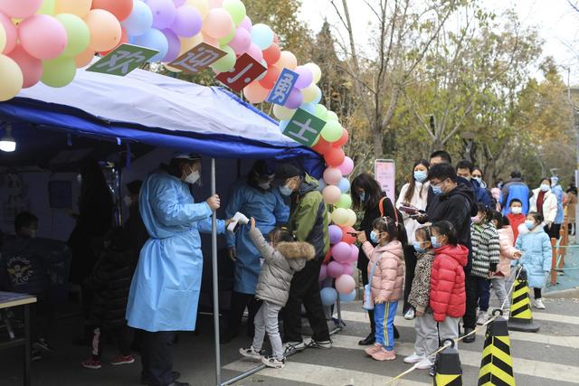 ▲家长带着小朋友们进入疫苗接种点。新京报记者 浦峰 摄