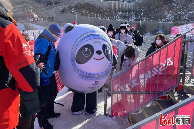 北京冬奥会吉祥物"冰墩墩"来到国家高山滑雪中心与人们互动,活跃现场