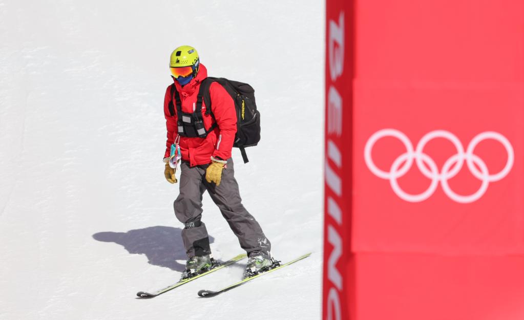 2月6日，男子滑降比赛宣布延期举行后，一名工作人员从雪道上滑下。新华社记者陈斌摄