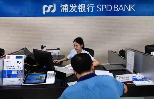 图为在浦发银行海口分行，一名银行工作人员在为客户办理业务。