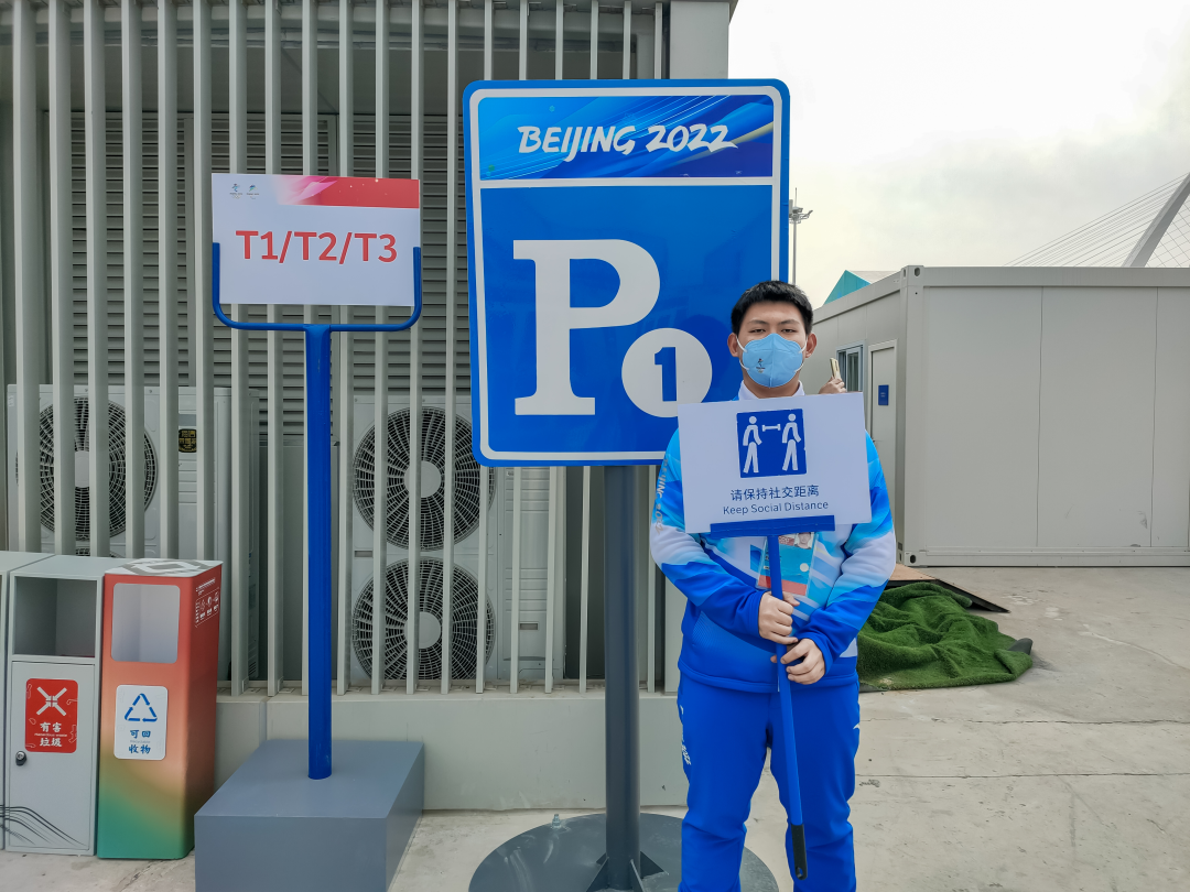 作为交通业务领域志愿者，刘培炎正在为来宾车辆做导引工作