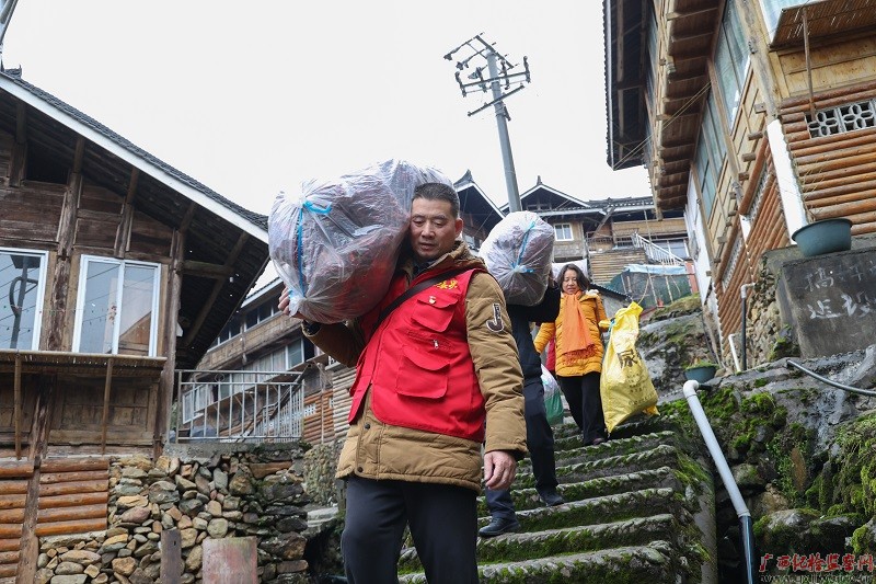 驻村工作队上门为脱贫困难户搬运单位认购的爱心辣椒。（黄显泉 摄）