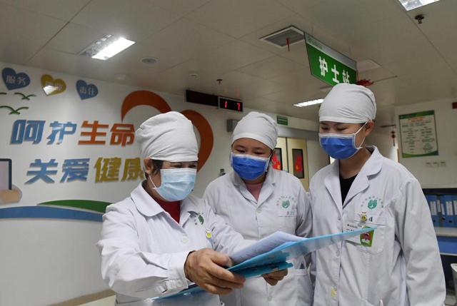 在广西南宁市第四人民医院，杜丽群（左）和护士交流病人用药情况。新华社记者 陆波岸 摄